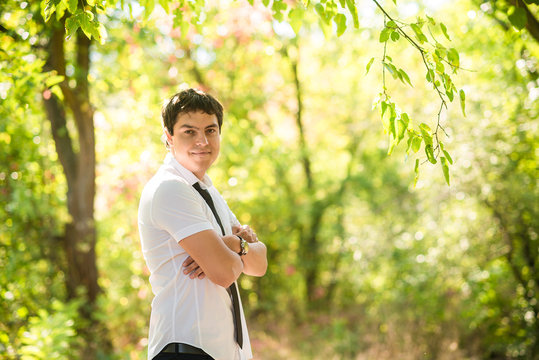man dressed white shirt and black tie standin near the tree