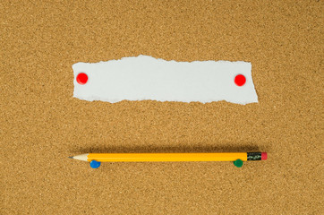 Note paper on cork board with pencil