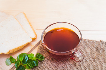 Cup of tea and bread on white wooden background