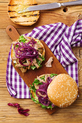 Obraz na płótnie Canvas Burger with meat of duck with red onion and lettuce.