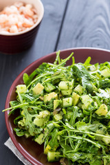 Beautiful Paleo Green Salad with Cucumber and Avocado on a Dark Grey Wooden Background with Plate of Shrimps, Vertical, Close-up
