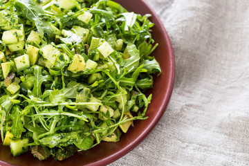 Beautiful Paleo Green Salad with Cucumber and Avocado on a Dark Grey Wooden Background, Horizontal, Close-up