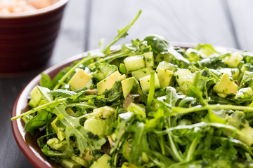 Beautiful Paleo Green Salad with Cucumber and Avocado on a Dark Grey Wooden Background with Plate of Shrimps, Horizontal, Close-up
