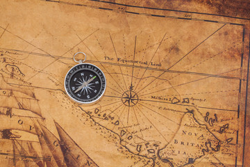 Old style brass compass on antique map