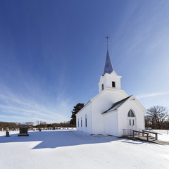 Fototapeta na wymiar Old white country church in winter with snow