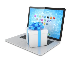 Gift box with ribbon bow on laptop keyboard