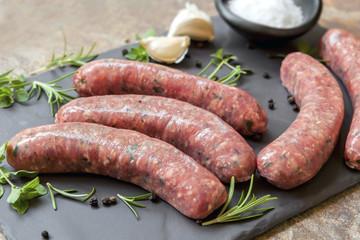 Raw Sausages on Slate with Herbs and  Spices - obrazy, fototapety, plakaty