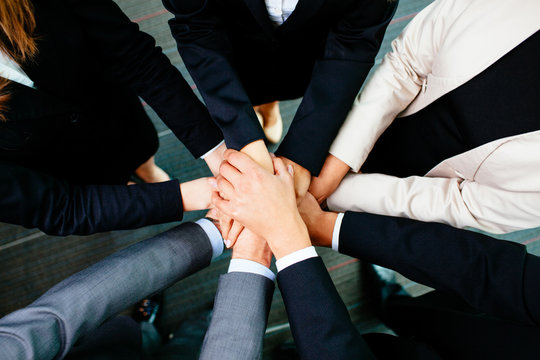 Overhead picture of business people joining hands
