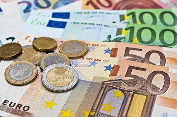 viele Eurogeldscheine und Münzen