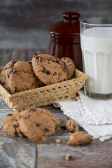 Tasty cookies and glass of milk on rustic wooden background