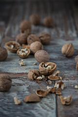 Walnut kernels and whole walnuts on rustic old wooden table