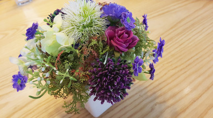 Colorful rose bouquet on wooden table