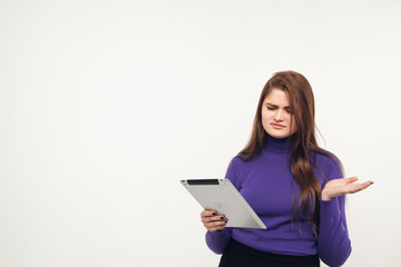 Fototapeta premium Young and beautiful teenager girl holding an ipad tablet pc in her arms over grey background