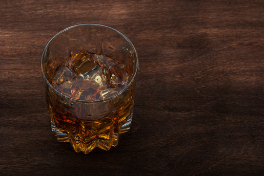 Glasses of whiskey on dark wood background