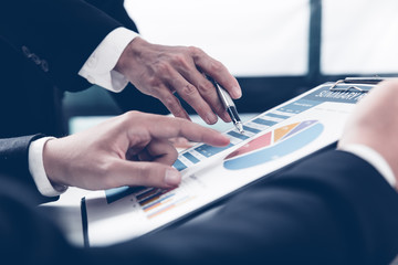Two businessmen looking at report and having a discussion in off