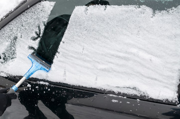Man Cleaning Car Window From Snow and Ice