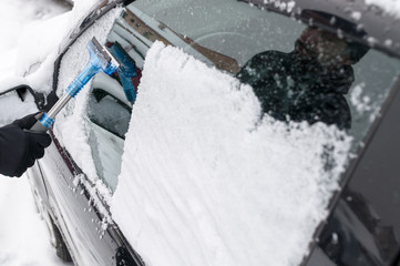Obraz na płótnie Canvas Man Cleaning Car Window From Snow and Ice