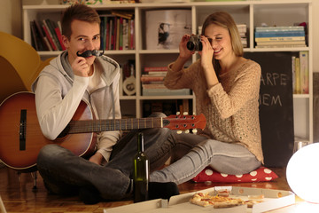 Cheerful couple having fun at home in the evening