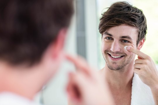 Smiling Handsome Man Applying Cream