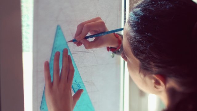 Teen girl tracing lines on plan
