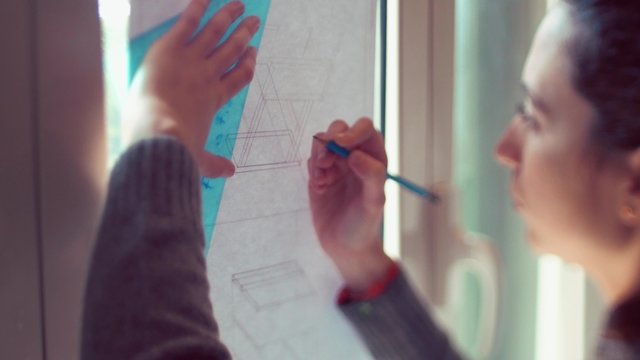 Teen girl tracing lines on plan
