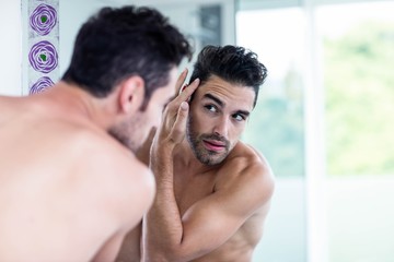 Handsome man looking at his hair