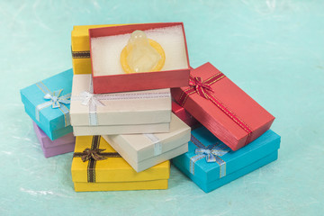 Yellow condom in small gift box on