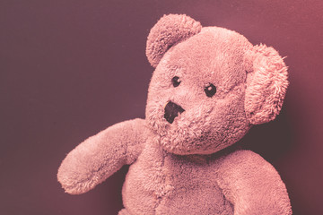 Lonely teddy bear on a dark background looking sad