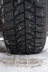 Winter tyre on the road covered with snow