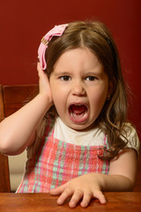 Expressive beautiful little girl playing indoor, face gesturing, miming, acting. Cute girl...