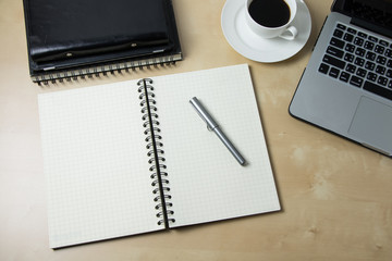 Working desk with coffee laptop glasses book notepad supplies and tablet  on wooden desk