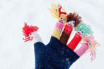 Closeup of funny women's woolen knitted gloves in winter on snow