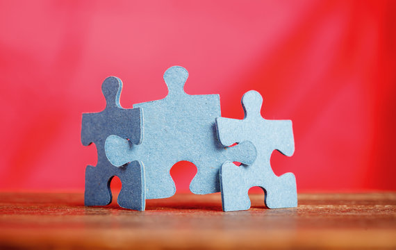 Three Jigsaw Puzzle Pieces On A Table