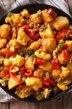 Indian food: Gobi Aloo close-up on the table. vertical top view