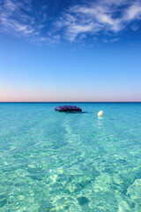 SUMMERTIME. The most beautiful sandy beaches of Apulia: inflatable mattress anchored white buoy,Porto Cesareo beach.-ITALY (Salento)-