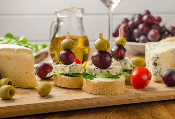 Delicious blue cheese with olives, grapes and salad