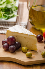Delicious blue cheese with olives, grapes and salad