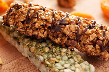 Granola bars on wooden board with fruits
