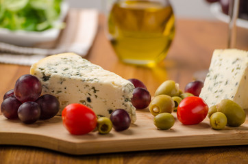 Delicious blue cheese with olives, grapes and salad