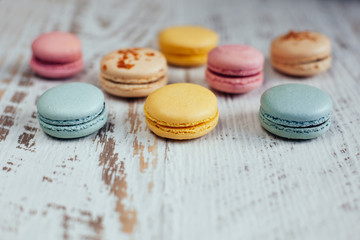 Colorful macarons on vintage on white wooden background