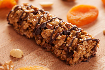 Muesli bar with chocolate on wooden board