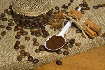 Coffee beans in the pot, ground coffee in a spoon, cinnamon, roa