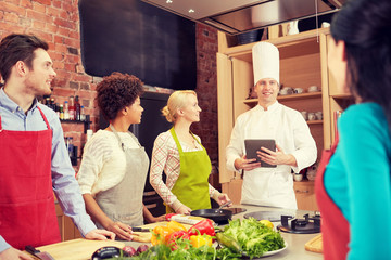 happy friends with tablet pc in kitchen