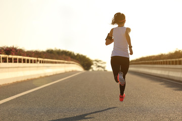 jeune femme fitness runner s& 39 exécutant sur la route du lever du soleil