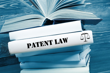 Book with Patent Law word on table in a courtroom or enforcement office. Toned image