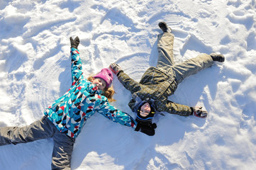 Girl and boy lying on snow