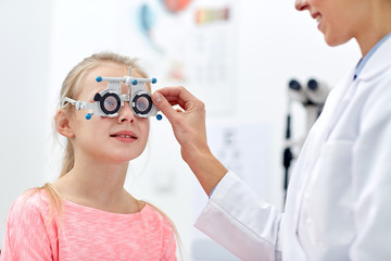 optician with trial frame and girl at clinic