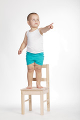 boy on chair and pointing his finger up