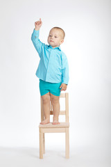 boy on chair and pointing his finger up