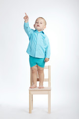 boy on chair and pointing his finger up